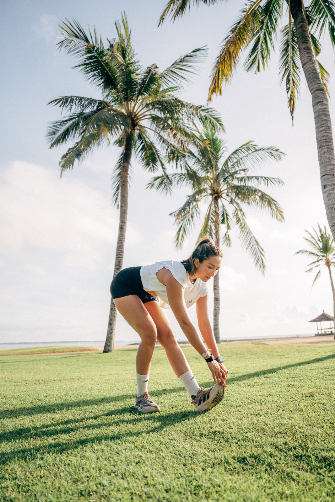 Andrea Dian, stretching sebelum berlari di pinggir pantai Nusa Dua
