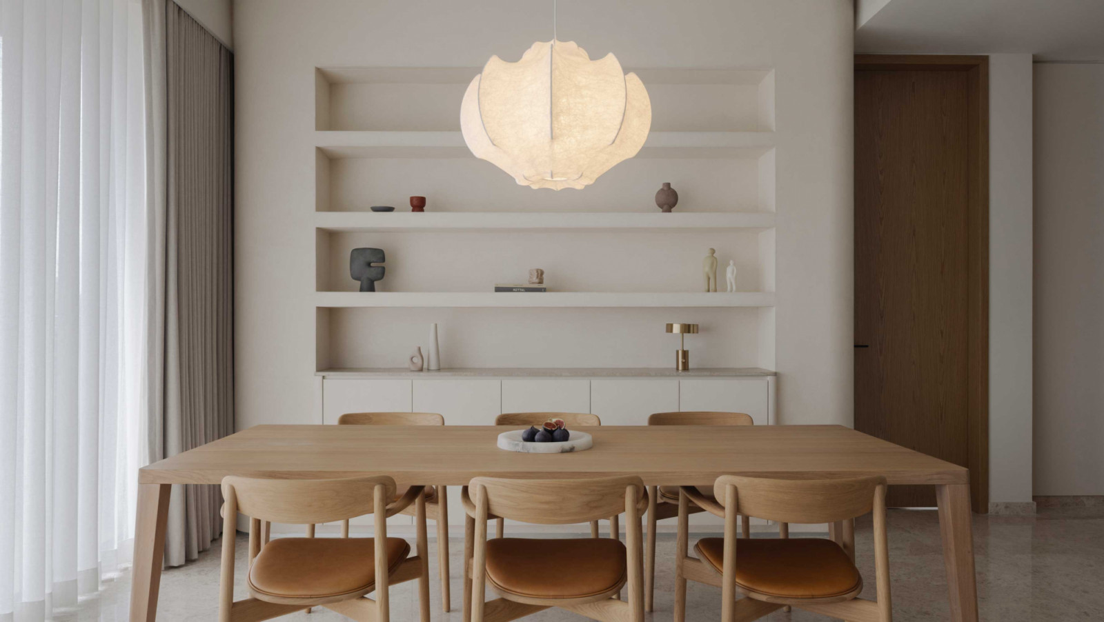A sculptural pendant light anchors the dining area in this River Valley apartment by EightyTwo