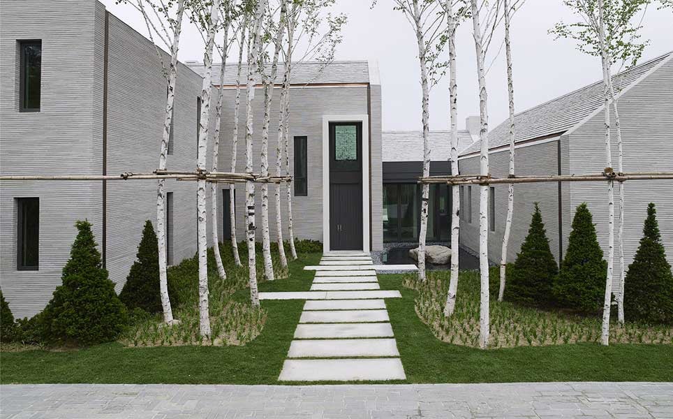 The arrival courtyard of the Piet Boon house at Oak Valley, planted with white birch and approached via a stone-paved path (Photo: Studio Piet Boon)