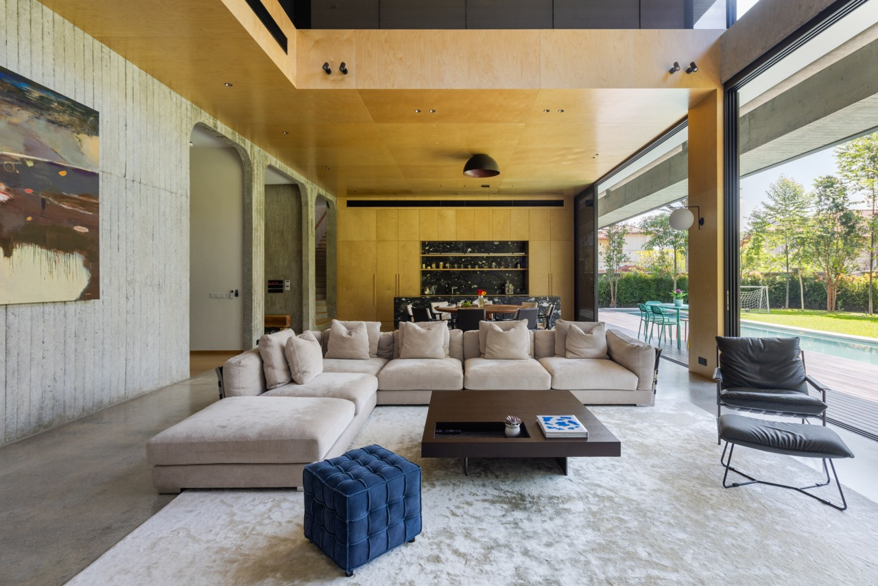A plywood ceiling introduces warmth to the open-plan living dining
hall, where polished concrete floors and a grooved concrete wall set the material register for the ground floor
