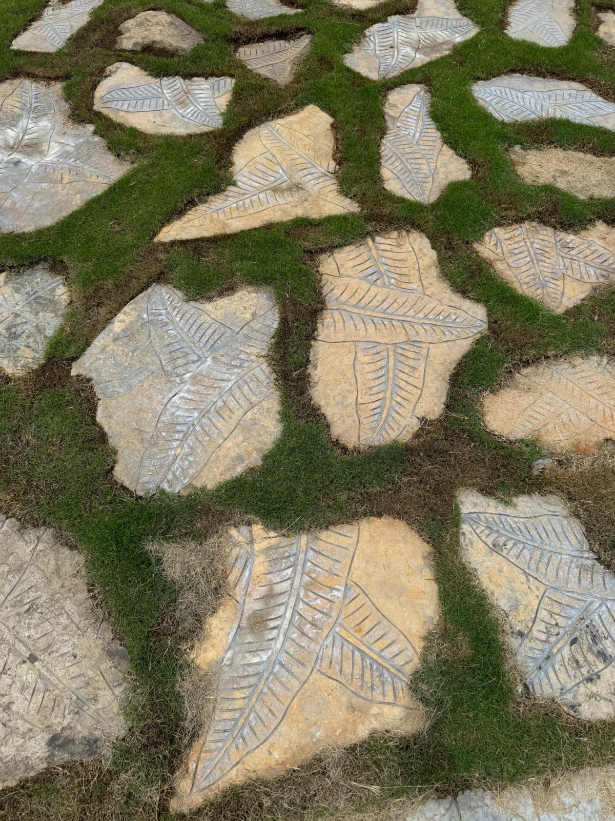 Leaf-imprinted natural stone flooring lines the pathways