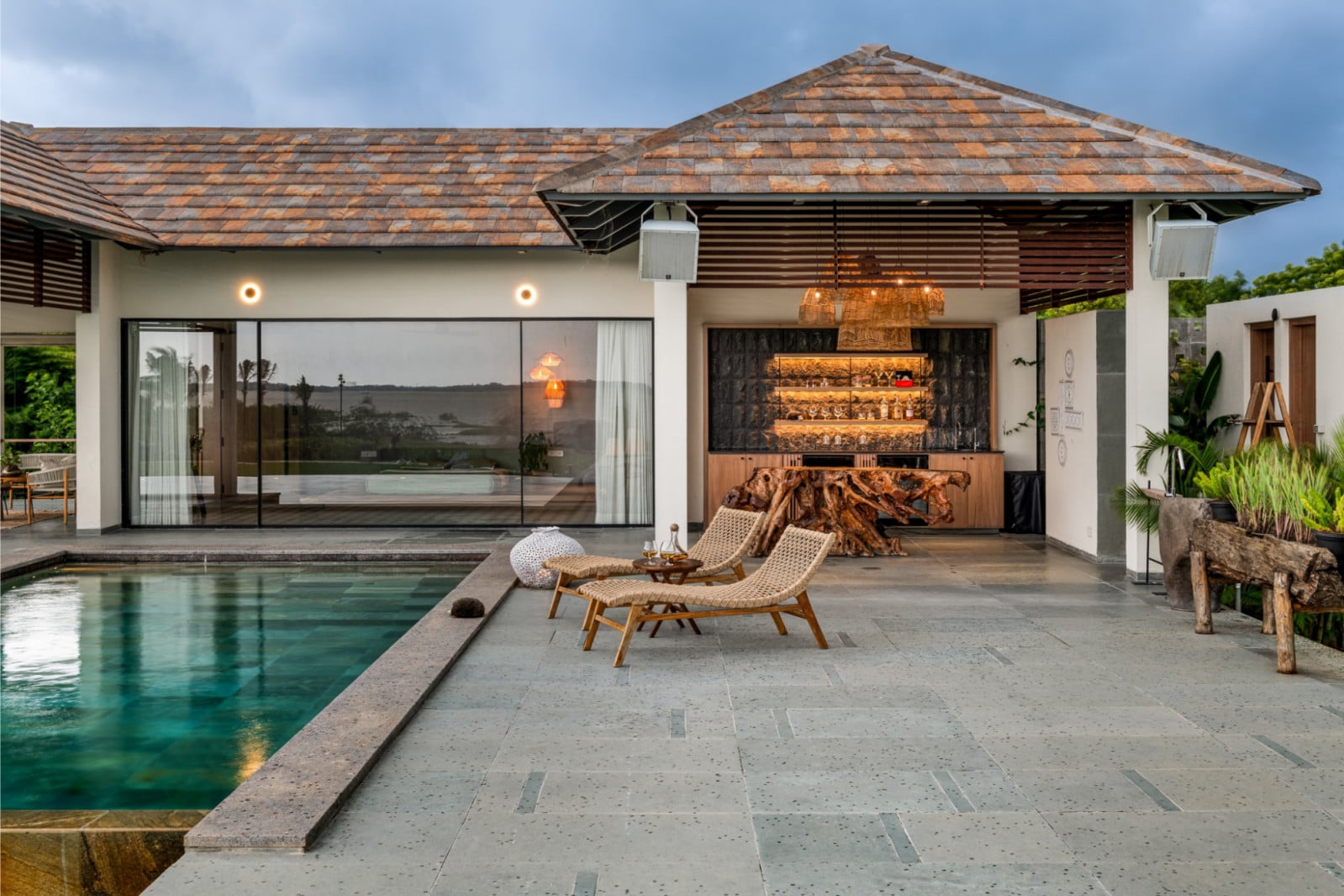 The detached bedroom pavilion with an outdoor bar functions as a private retreat within the retreat
