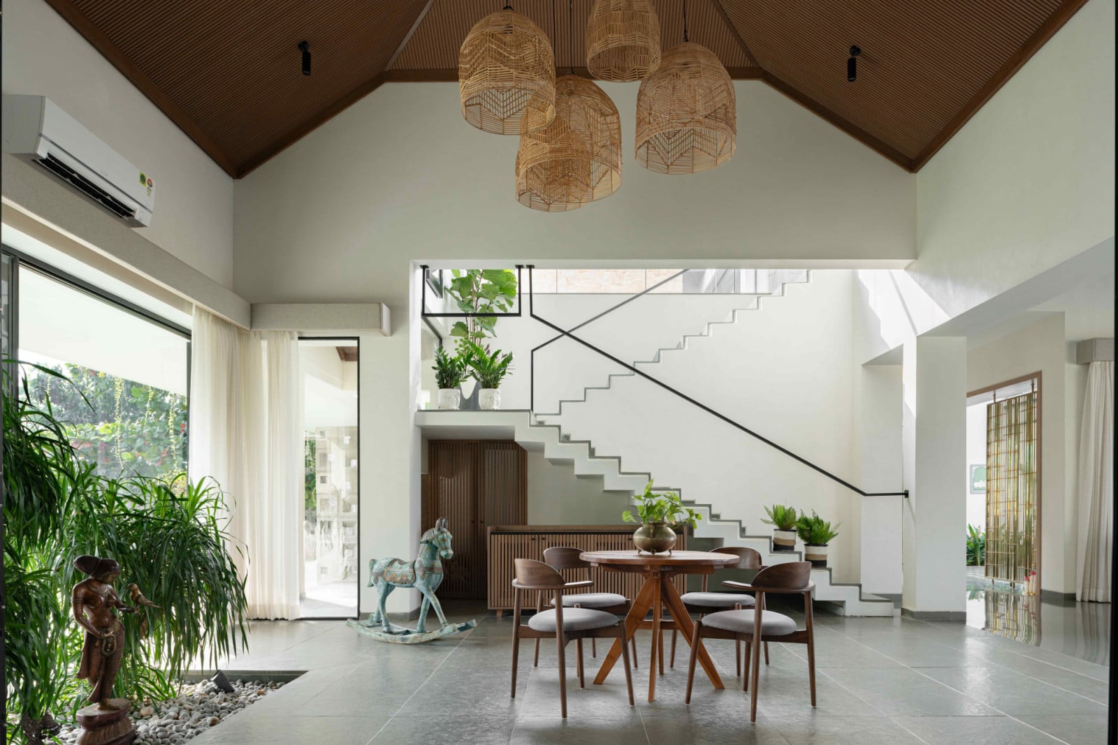 Crisp white walls, warm timber ceilings and lush foliage create a calm backdrop
