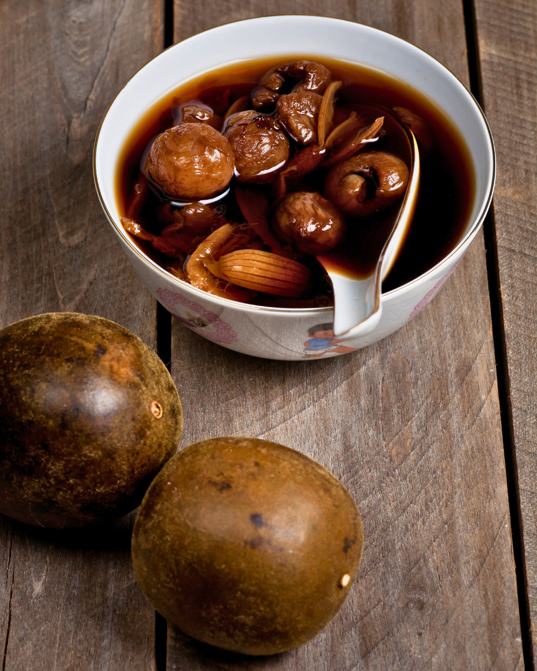 Monk fruit tea, a naturally sweet brew with dried longans, served alongside whole monk fruits.