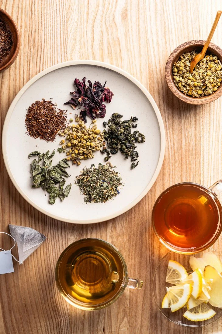 An assortment of loose leaf teas, including rooibos, hibiscus and oolong, prepared with fresh lemon and ginger.