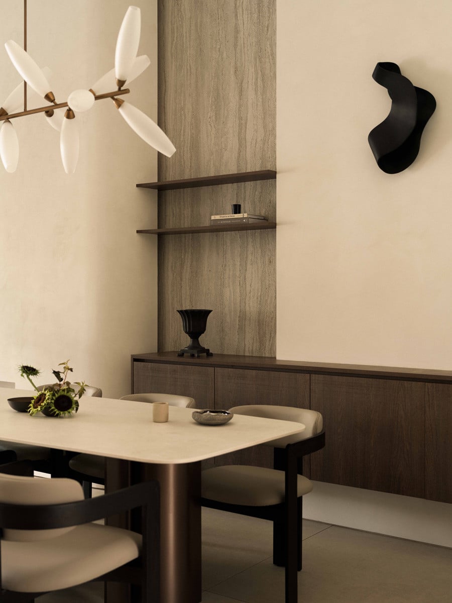 Dark timber shelving is recessed into a stone-clad wall in the dining room’s corner
