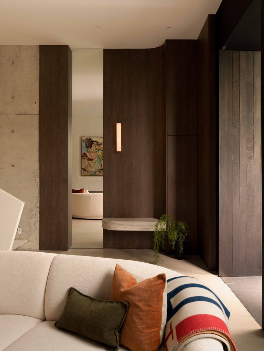 Dark timber volumes frame a view to the living room