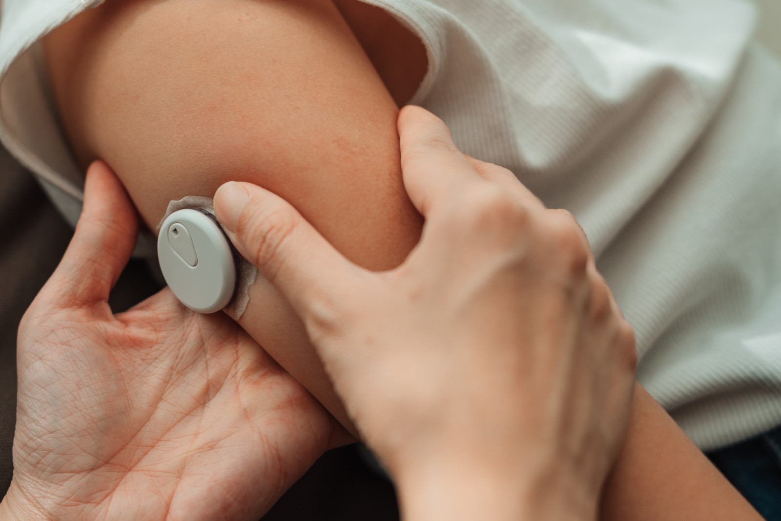 Modern mom using CGM device to check her daughter's blood sugar level, ensuring her health is closely monitored in real-time, embracing the power of technology to manage her child's health
