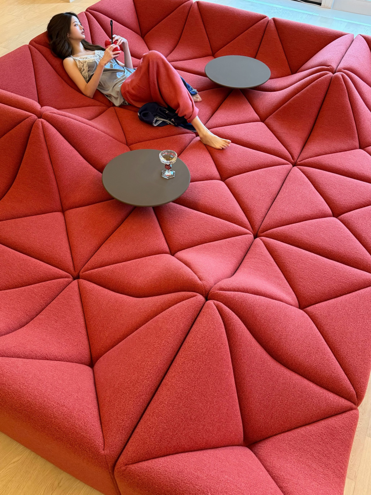 Wonyoung reclining on the Pierre Paulin Dune sofa in red