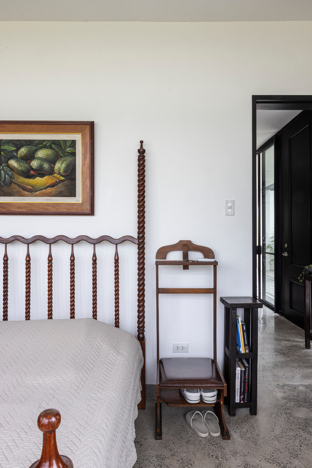 The bedroom of a black-and-white heritage home designed by architect Miko De Los Reyes of Imagimax in Manila, Philippines