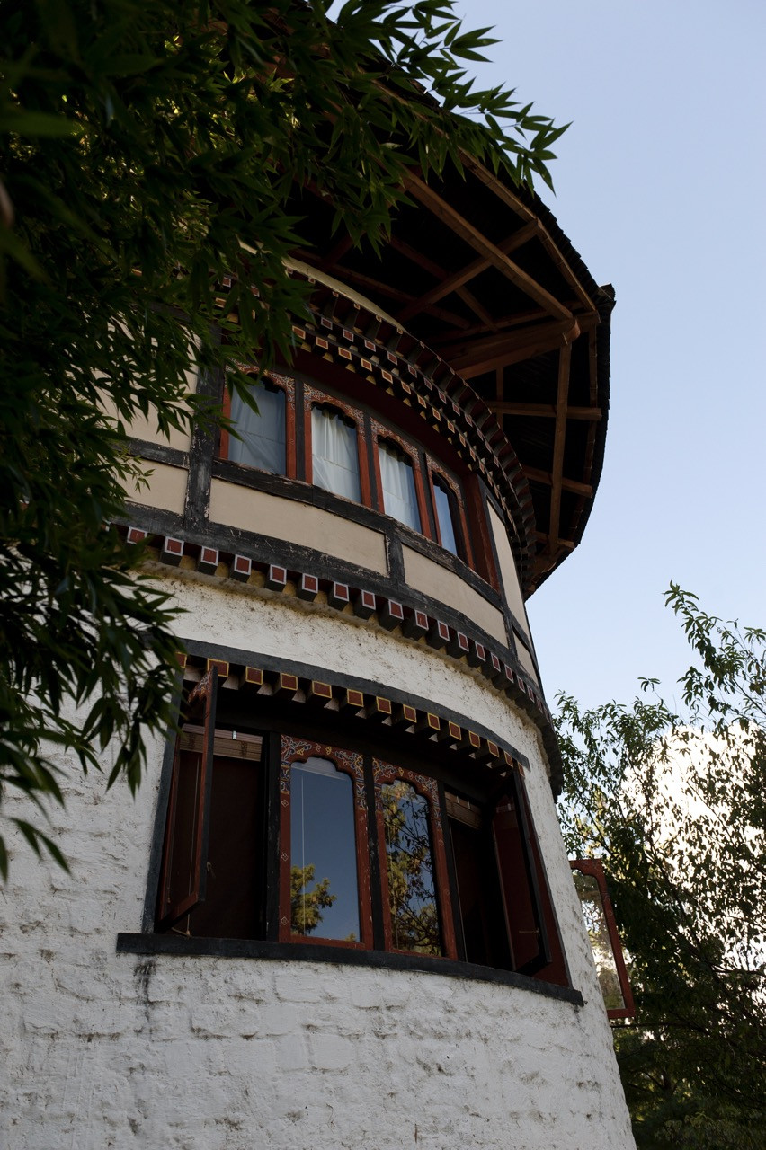 A rounded, painted-window turret forms part of Uma Paro’s main building, detailed with traditional Bhutanese woodwork