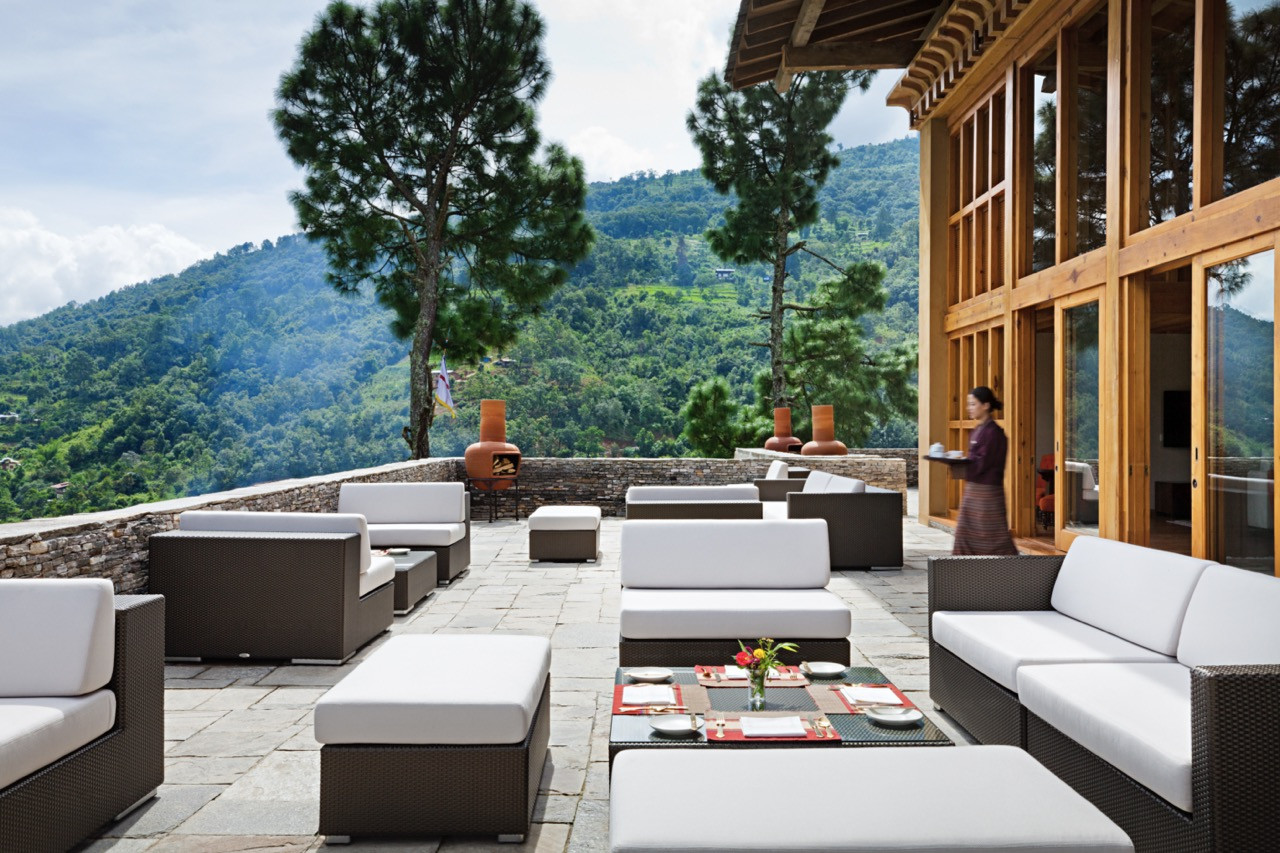 The terrace at Uma Punakha’s main building looks out over pine-covered hills and rice terraces beyond