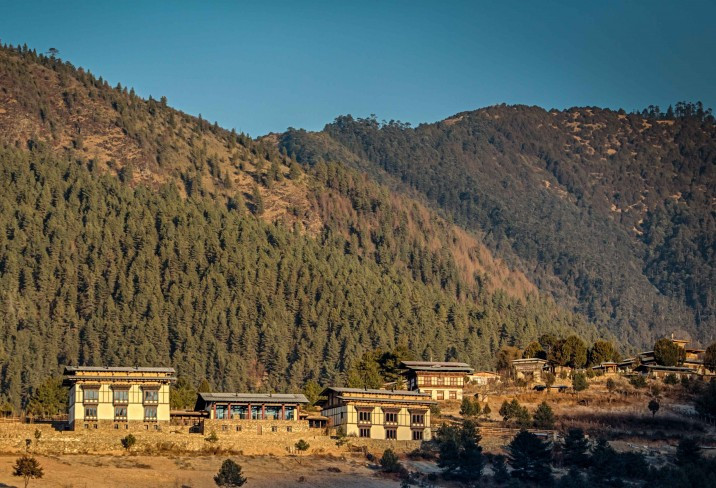 Gangtey Lodge’s stone-and-timber buildings sit low against the pine-covered slopes of the Phobjikha Valley