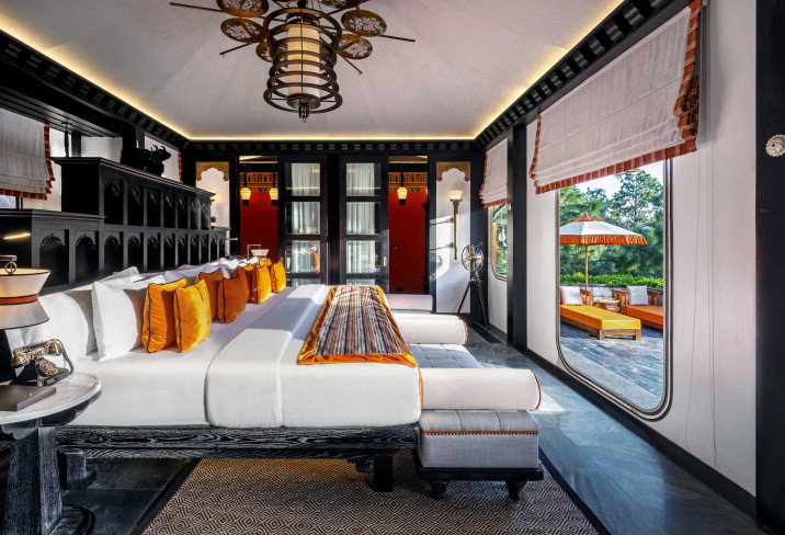 A black-and-orange suite in a luxury tented villa at Pemako Punakha opens onto a private terrace, its arched doorways drawing on dzong window forms
