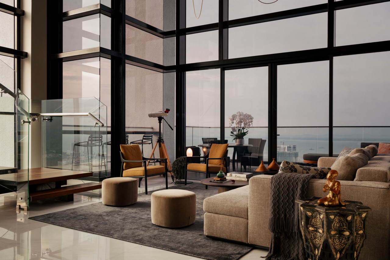 The double-height living hall, anchored by the Molteni&C sofa, opens out to panoramic sea views through floor-to-ceiling glazing