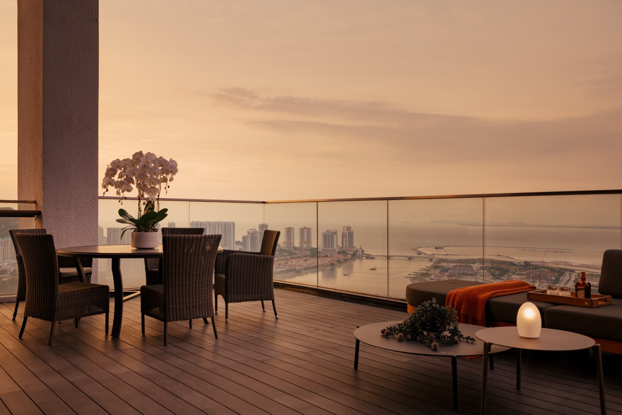 The balcony at dusk with sweeping views across Penang’s waterfront and coastline