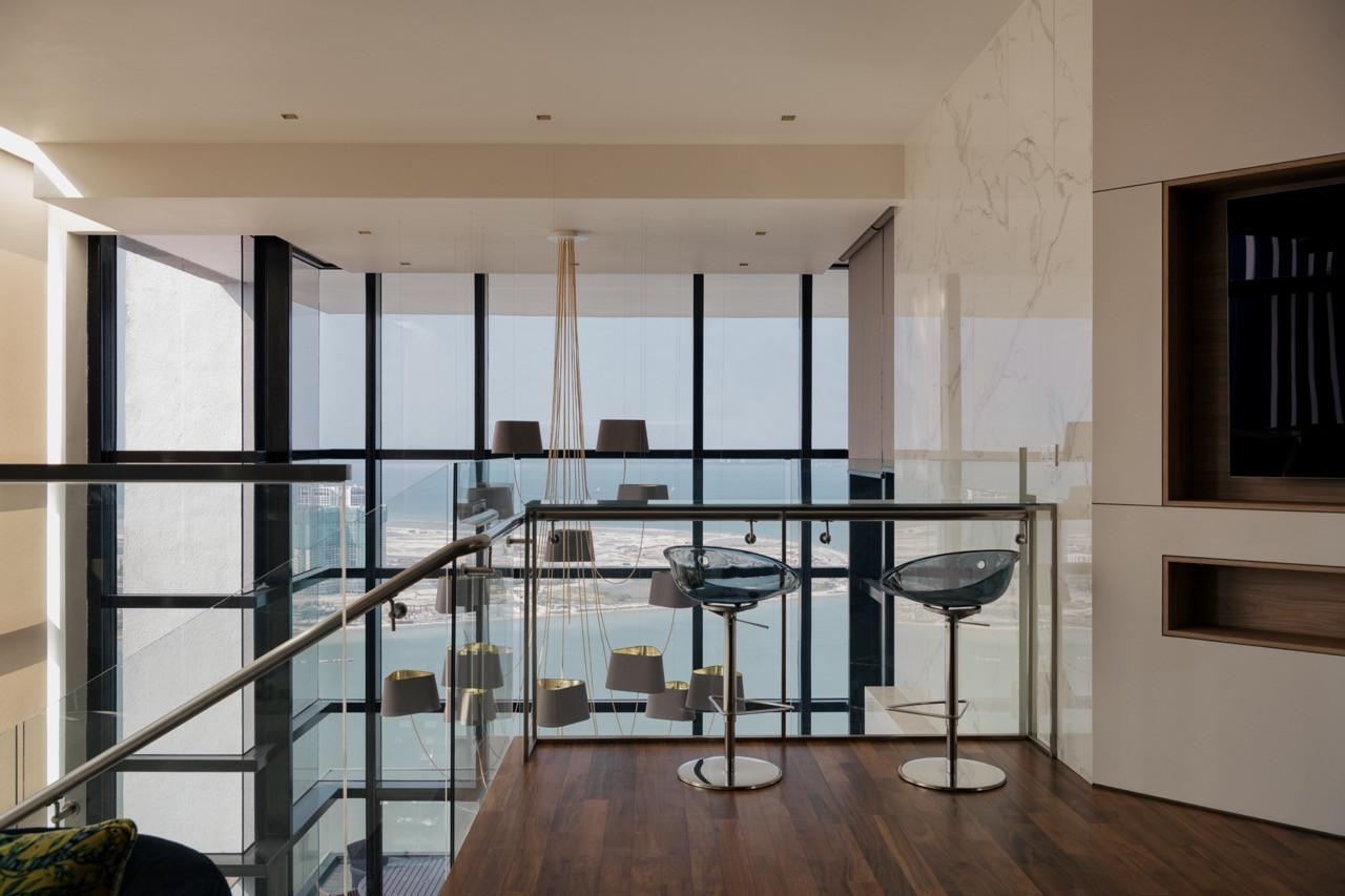 Pedrali Gliss barstools line the upper-level counter overlooking the double-height living hall below