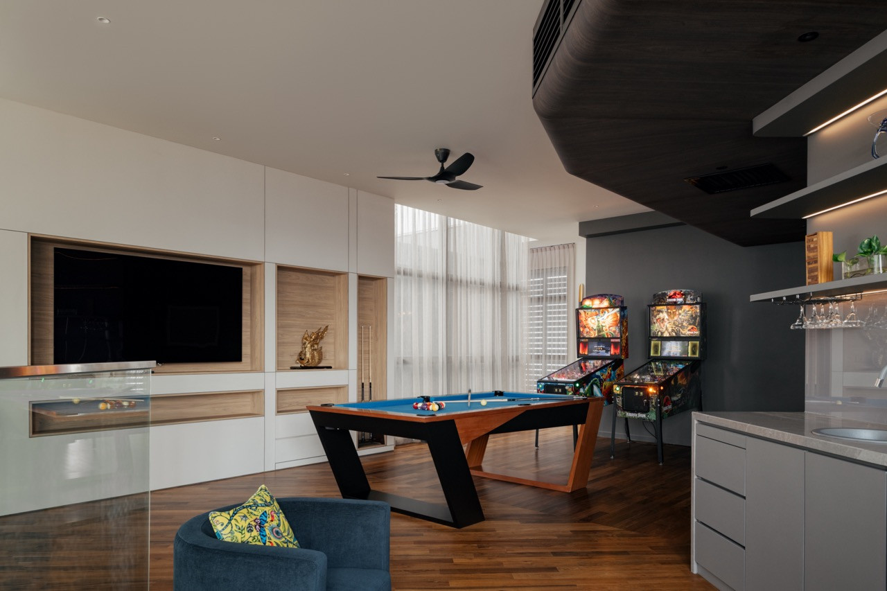 The entertainment hall accommodates a pool table, pinball machines, a TV wall unit with timber-lined niches