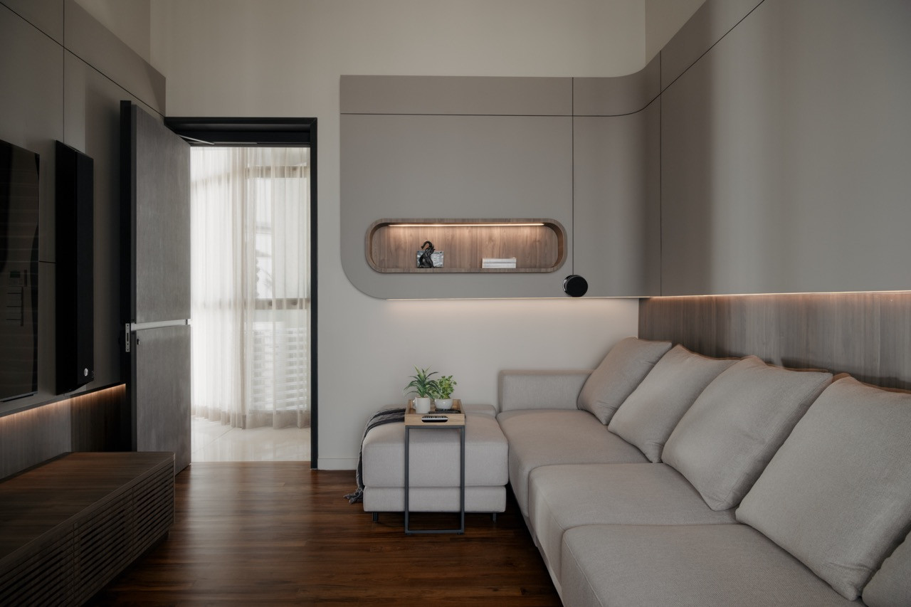 The entertainment room’s soft grey sectional sofa sits opposite a timber-lined niche