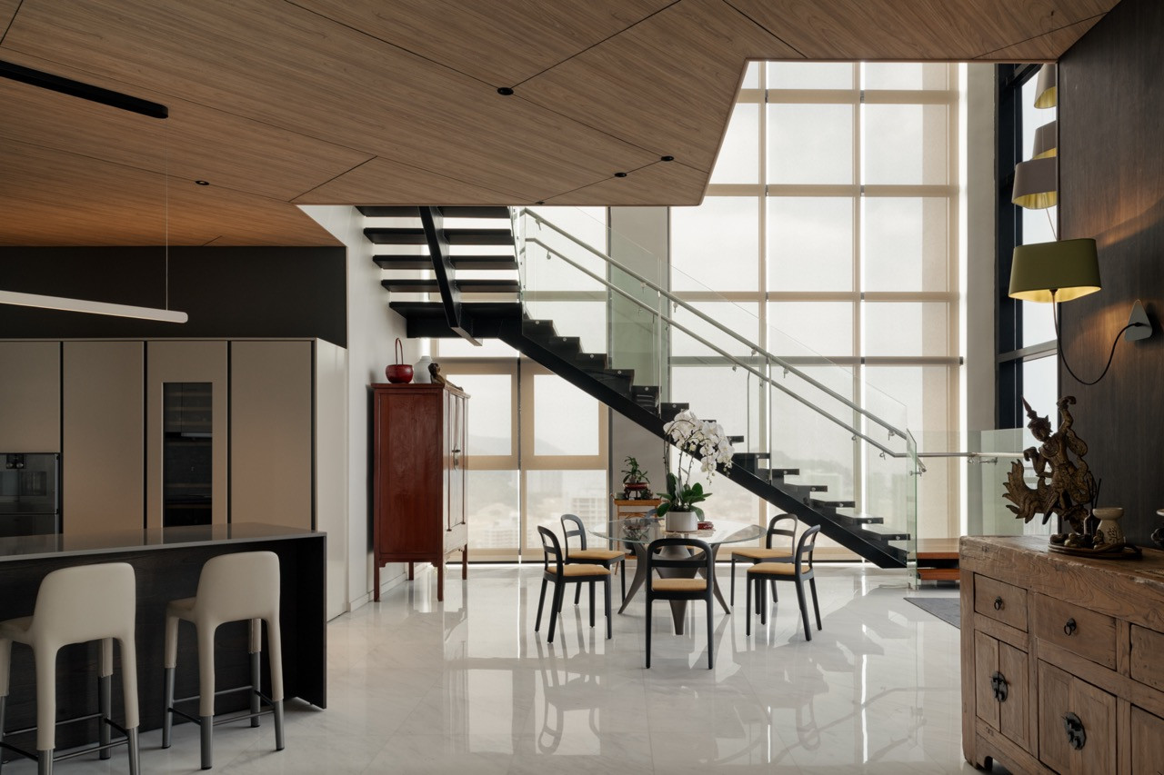 Looking across the Calacatta marble floor, the dry kitchen island and red lacquered cabinet punctuate an otherwise open and luminous floor plan