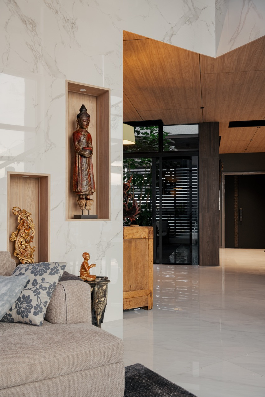 Lightly veined Calacatta marble walls and a timber-lined niche mark the transition between the living area and the private foyer beyond