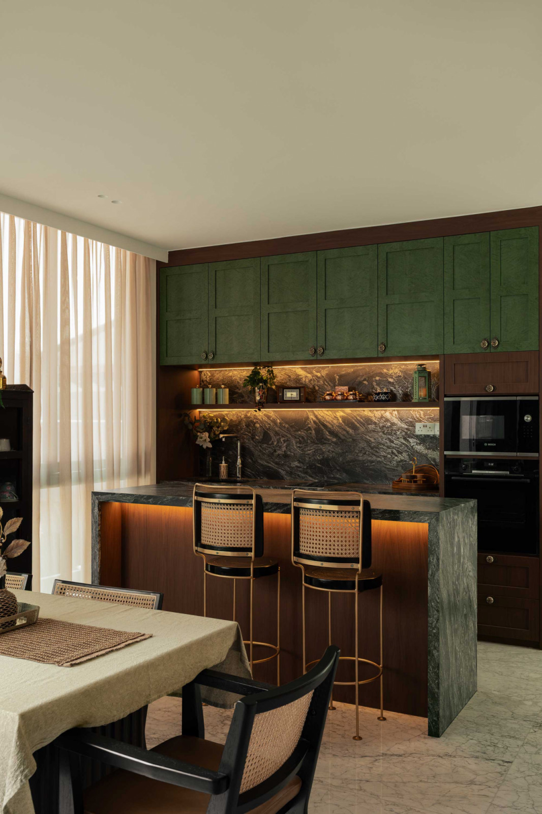 Green cabinetry and a stone island define the kitchen