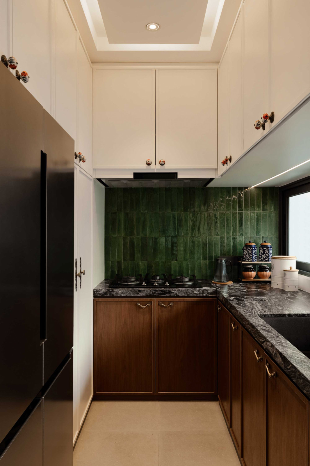 The compact kitchen’s green tiles lend freshness