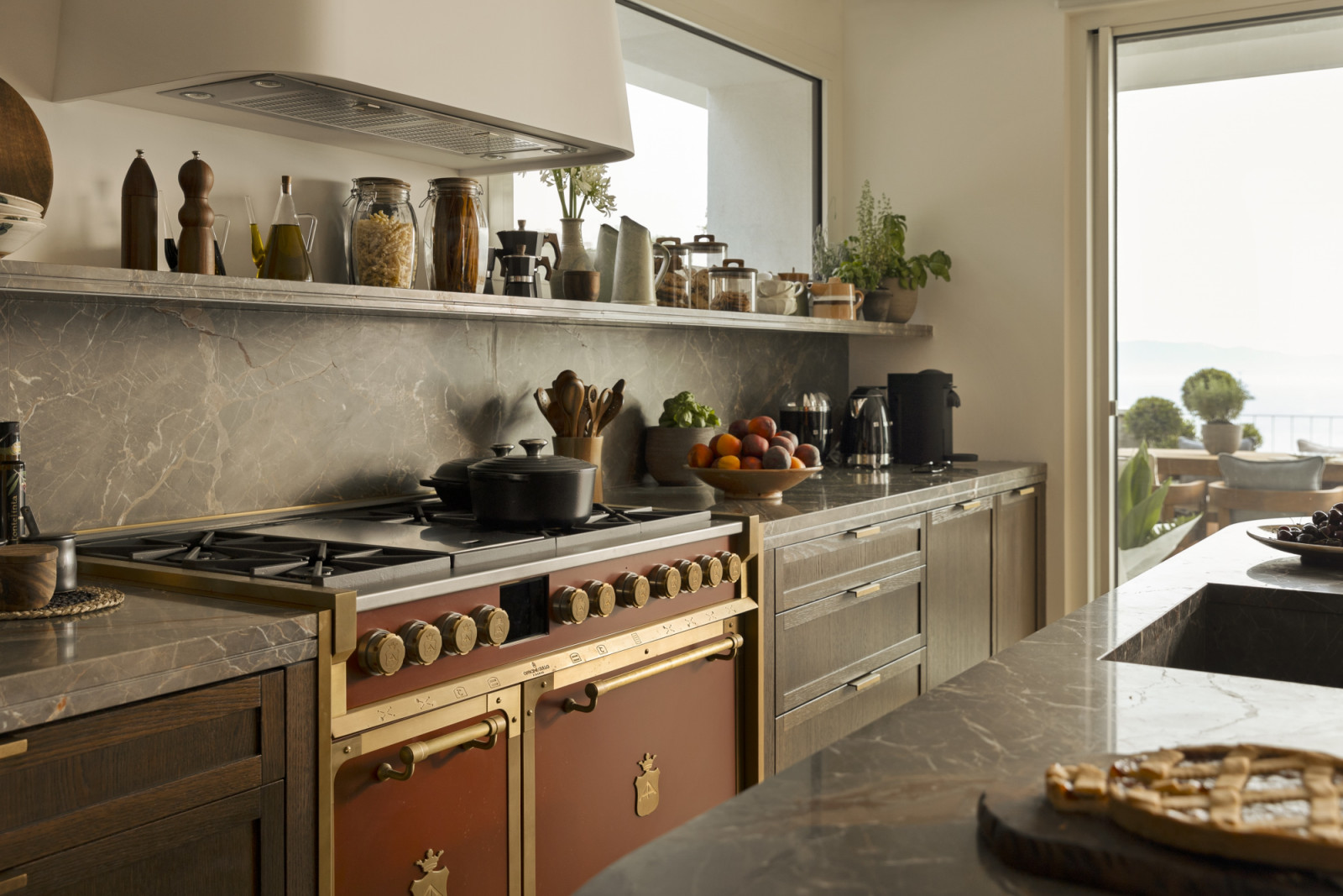 A custom Officine Gullo cooker in terracotta red and dark walnut cabinetry