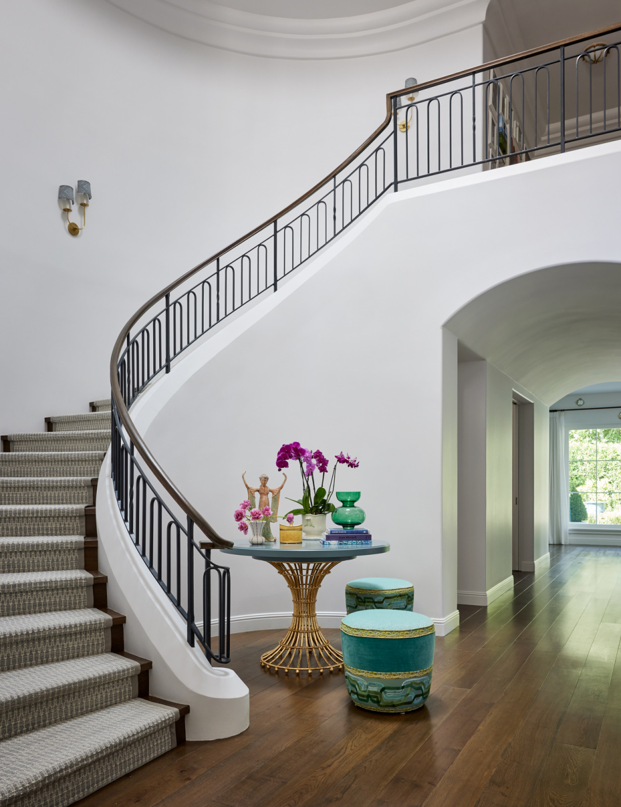 Curved staircase with custom steel balustrade, replacing the original wrought-iron design