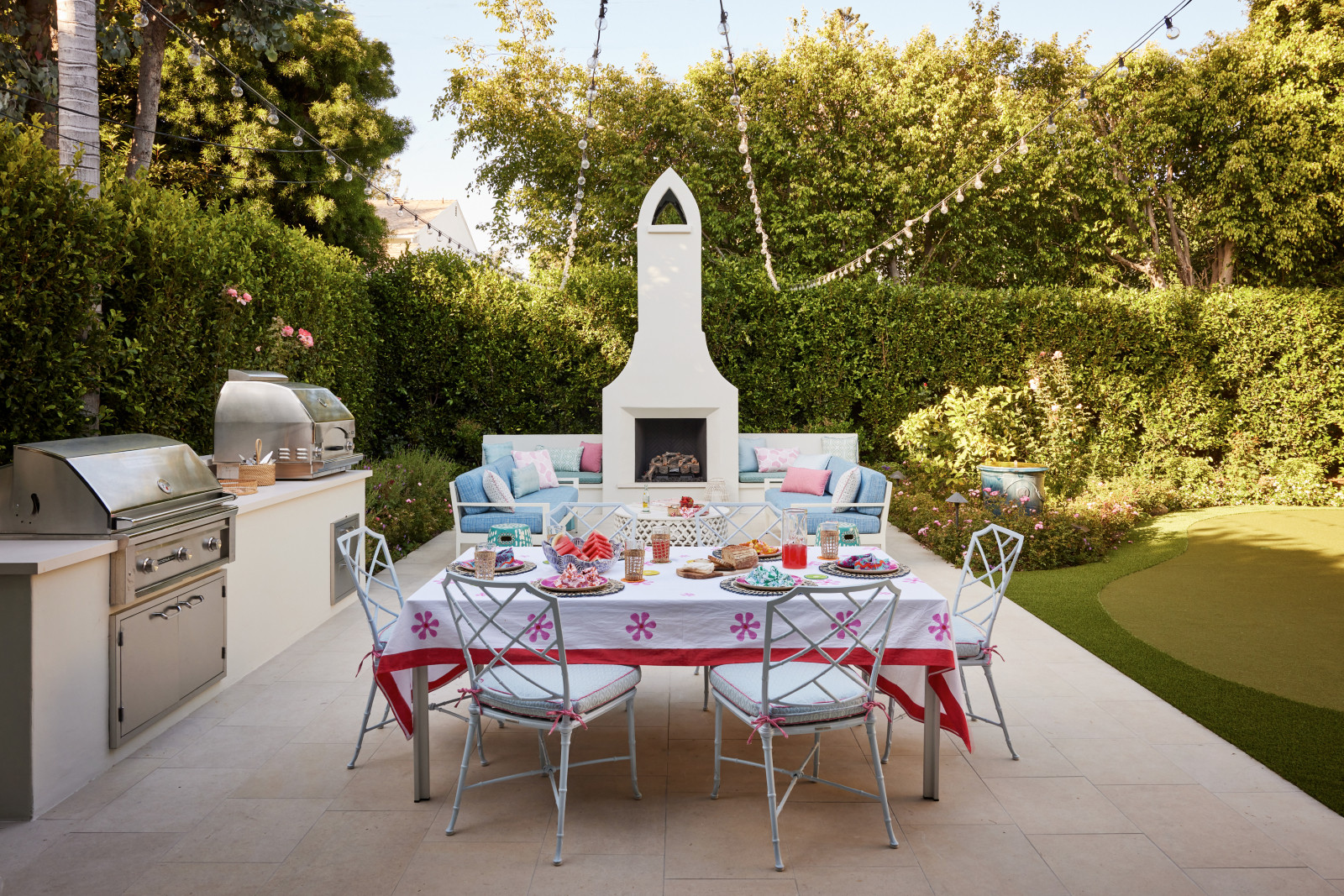 The landscaped back garden features an outdoor kitchen, fireplace, and dining terrace creating a relaxed setting for entertaining.