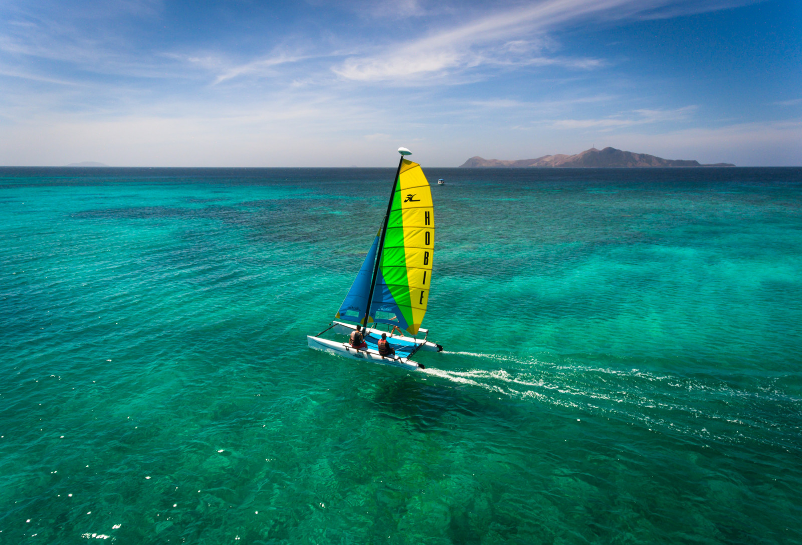 A Hobie catamaran with guests navigates the turquoise waters of Amanpulo.