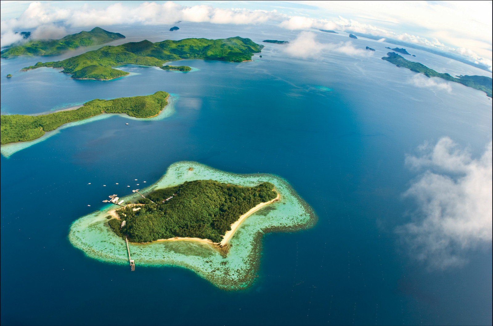 Pamalican Island, home to Amanpulo, reveals its pristine beaches and vibrant coral reefs from above.
