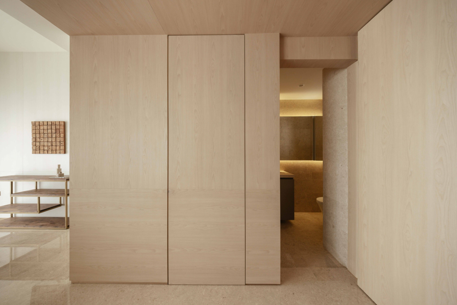 Light oak panelling wraps the entrance, concealing a doorway through to the ensuite