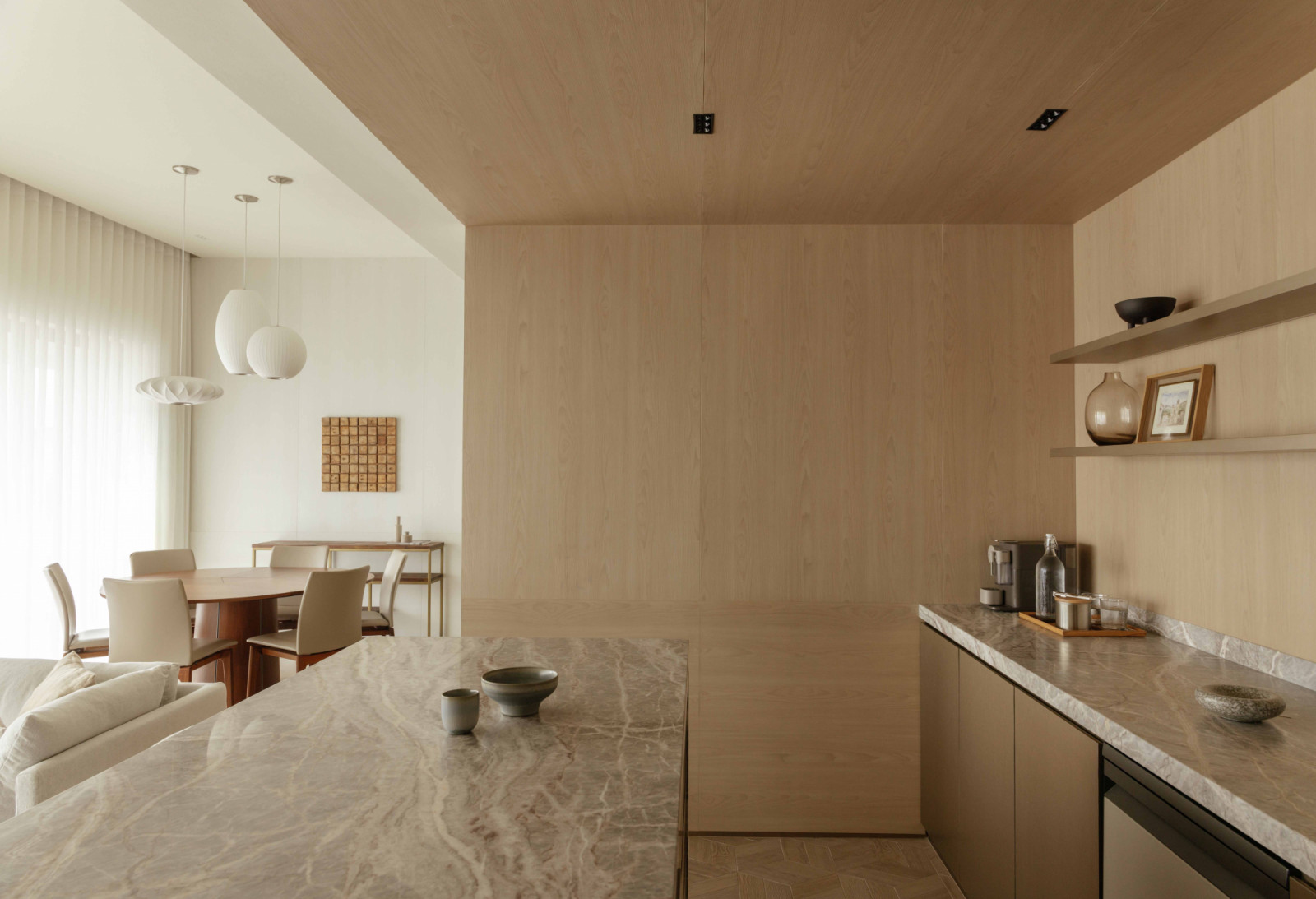 The marble island opens onto the dining and living areas beyond, unifying the penthouse's social spaces