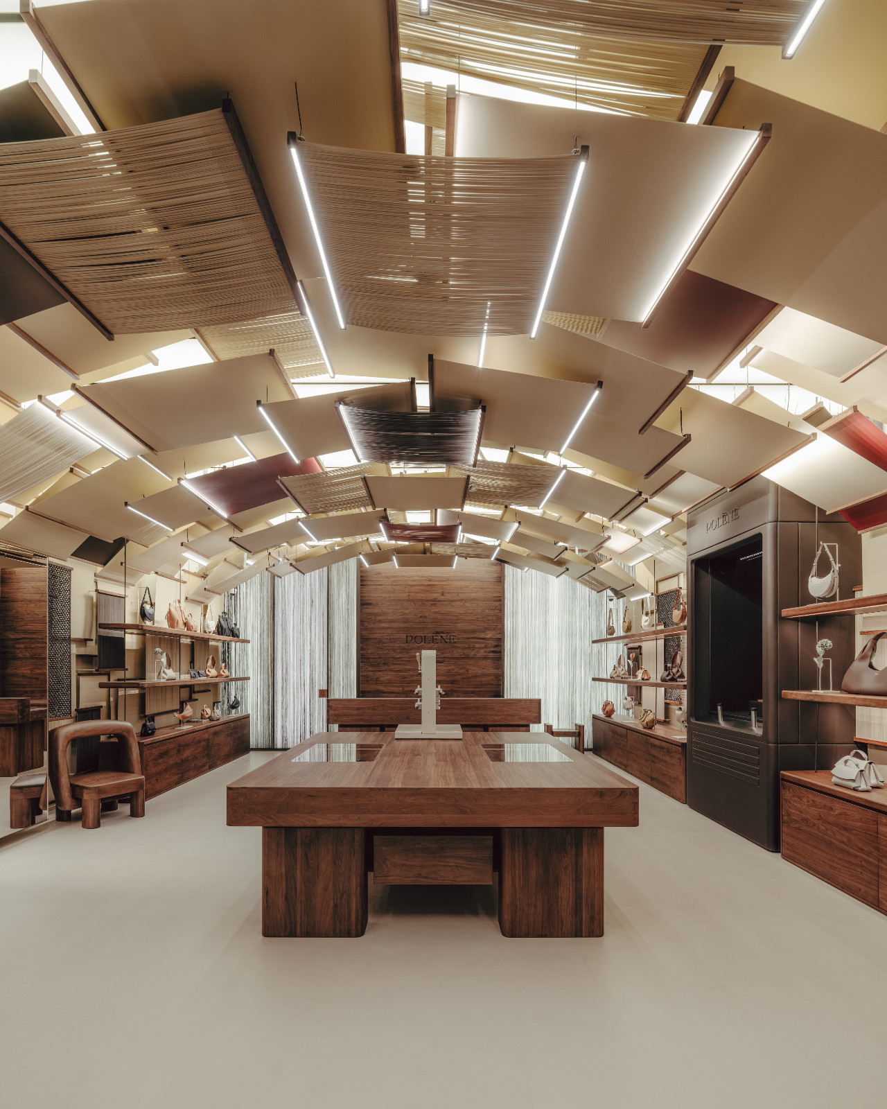Polène Singapore boutique's interior features bespoke dark wood furnishings and a distinctive layered ceiling design.