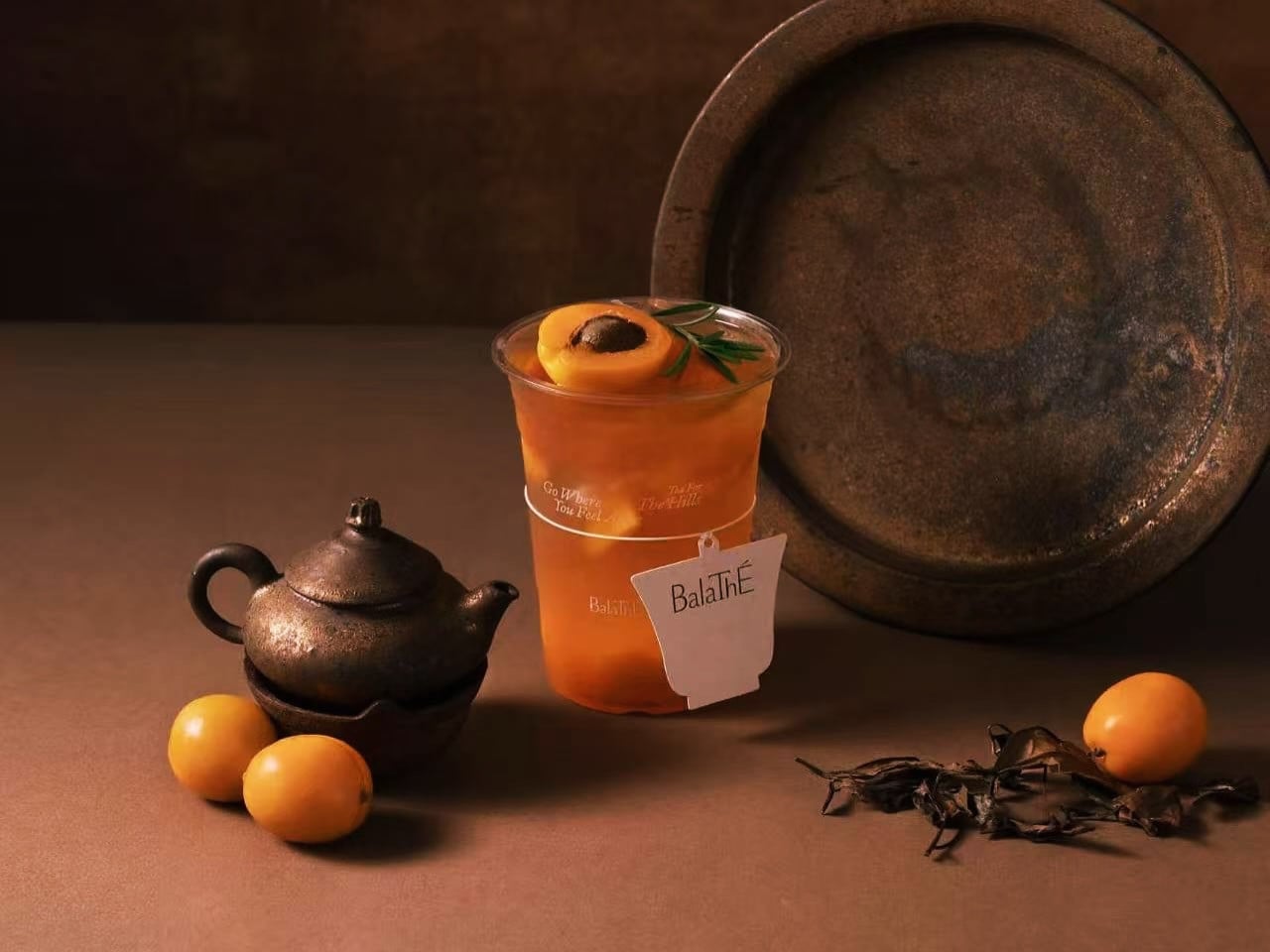 BalaThÉ's apricot iced tea, a popular beverage in Shanghai, presented with traditional tea elements and fresh fruit.