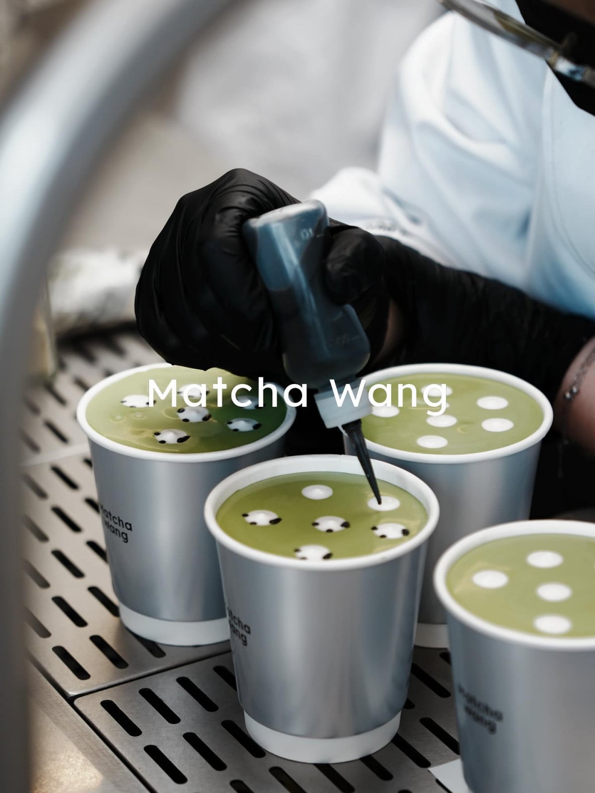 A barista crafts Matcha Wang beverages with intricate latte art, a popular indulgence in Shanghai.