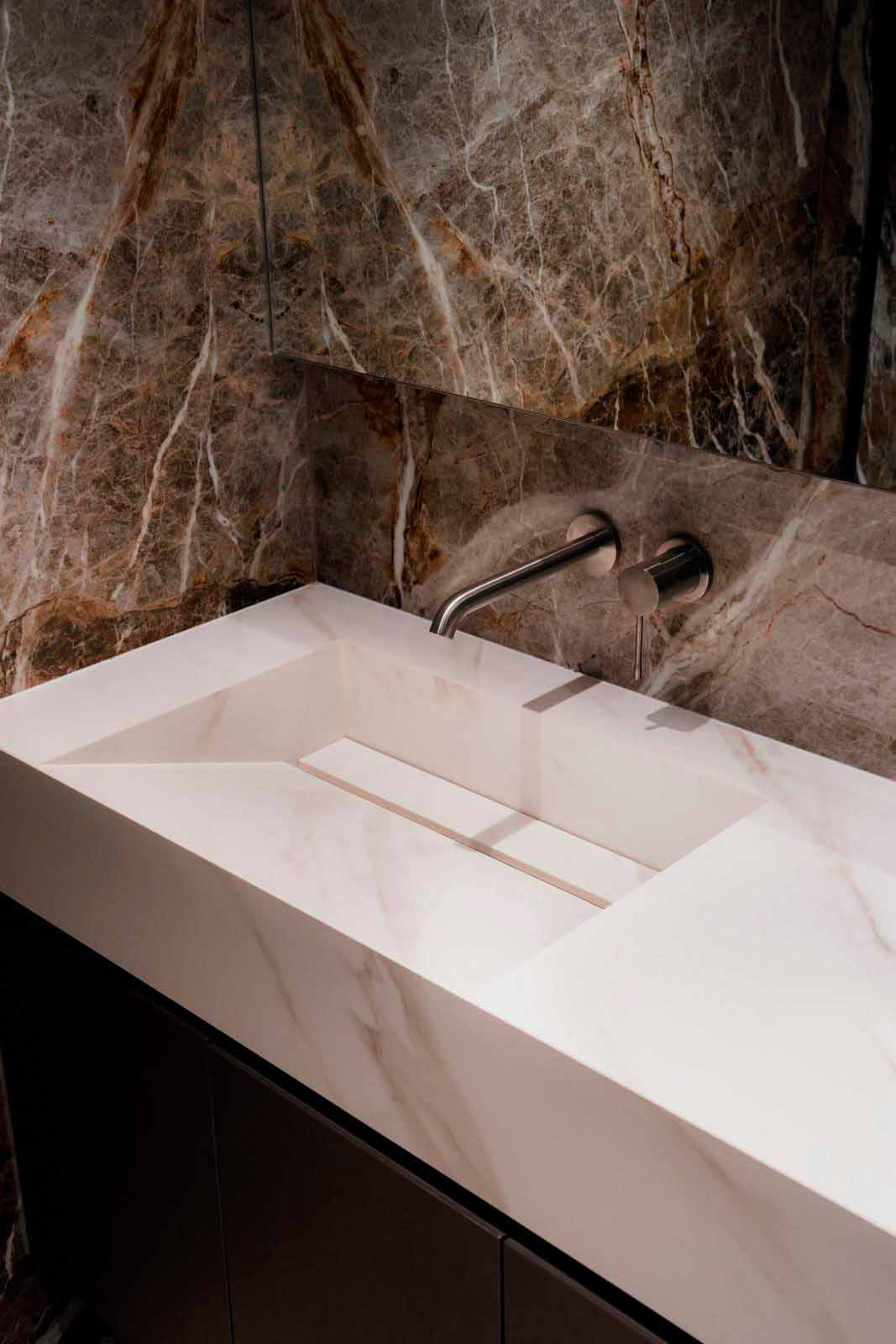 The bathroom’s vanity area uses two types of marble in contrasting colours