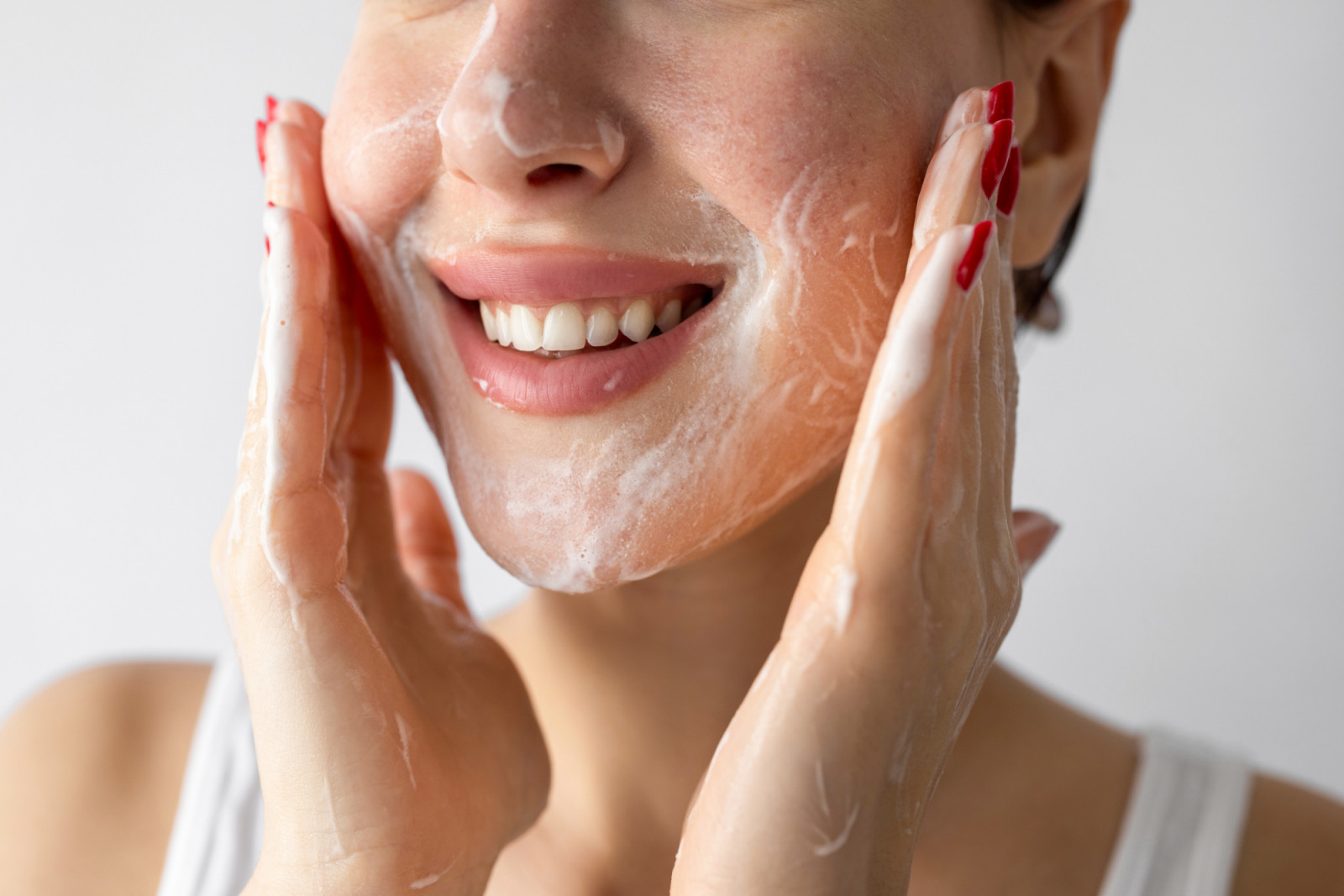 Unrecognizable woman washing her face with skin cleanser