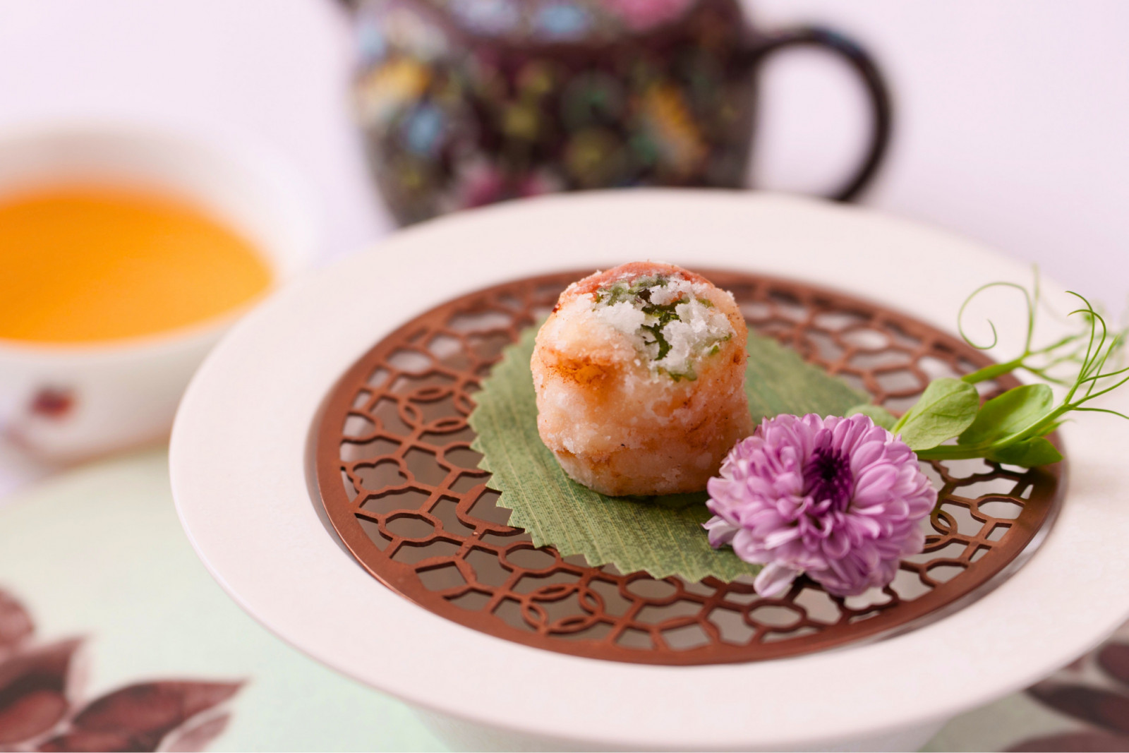A gourmet prawn fritter, intricately plated with a purple chrysanthemum, by Ming Court.