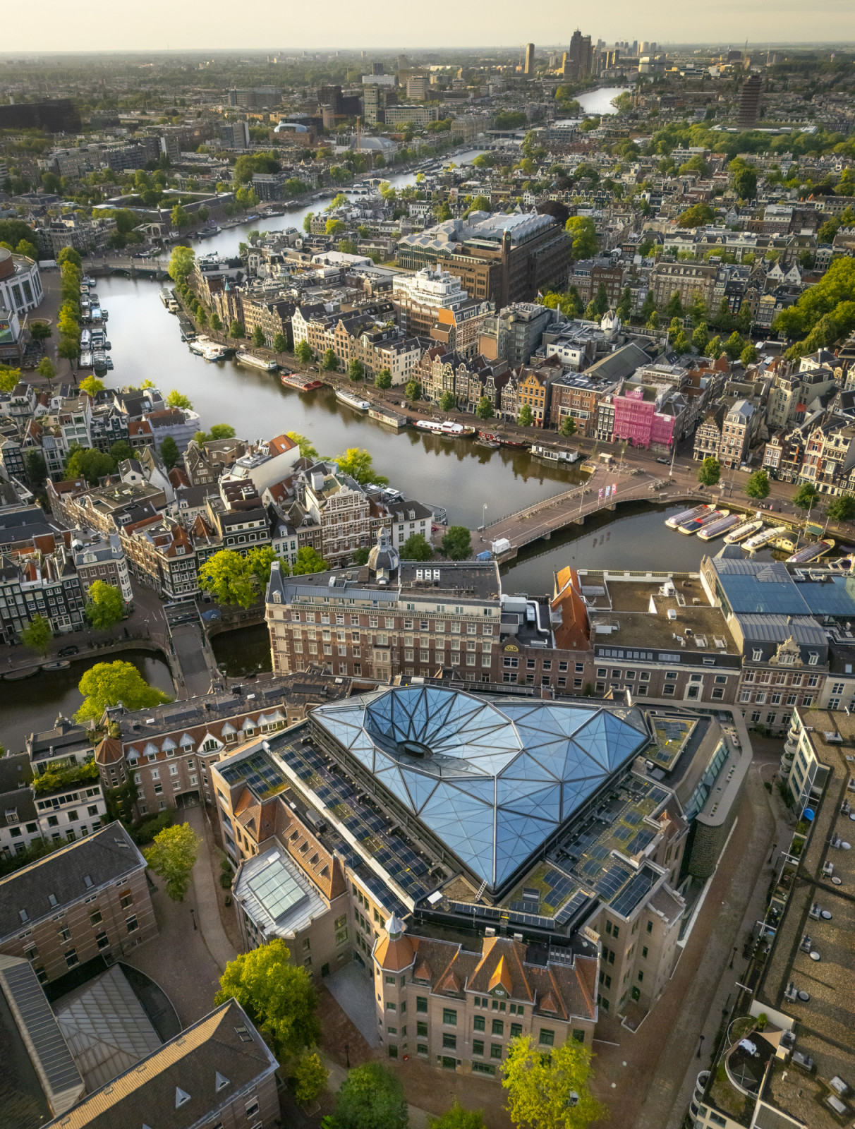 Seen from above, the library’s faceted glass roof sits within a courtyard enclosed by the original hospital complex’s pitched brick wings (Photo: Jannes Linders)