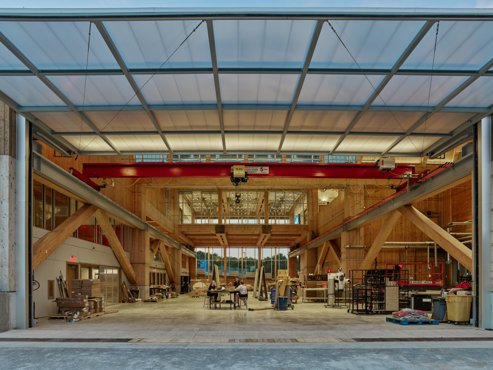 A red gantry crane spans the double-height workshop, framed by diagonal timber bracing on both sides (Photo: Timothy Hursley)