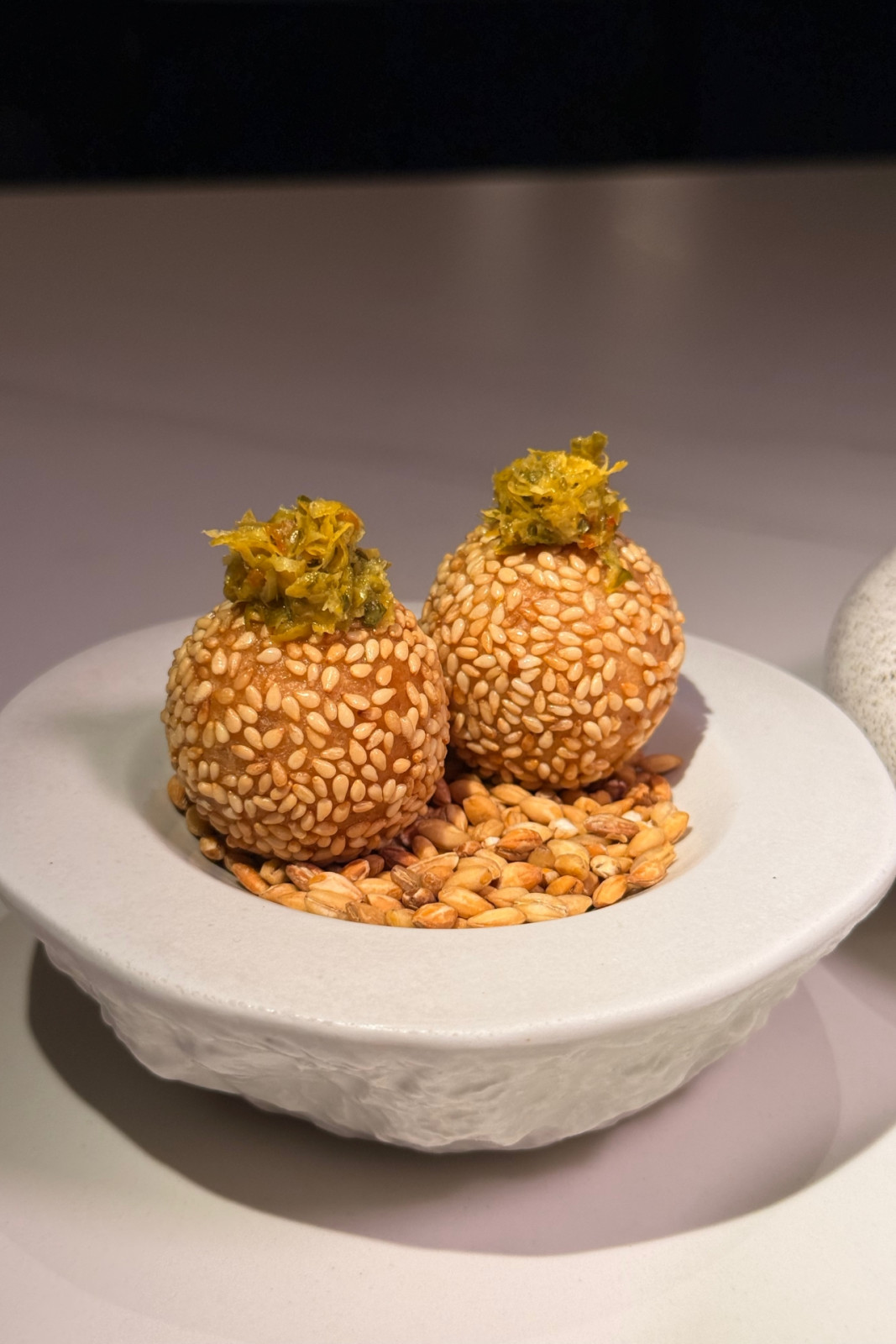 Savoury buchi with toasted sesame, lobster and prawn bisque, lime kosho from Helm by Josh Boutwood