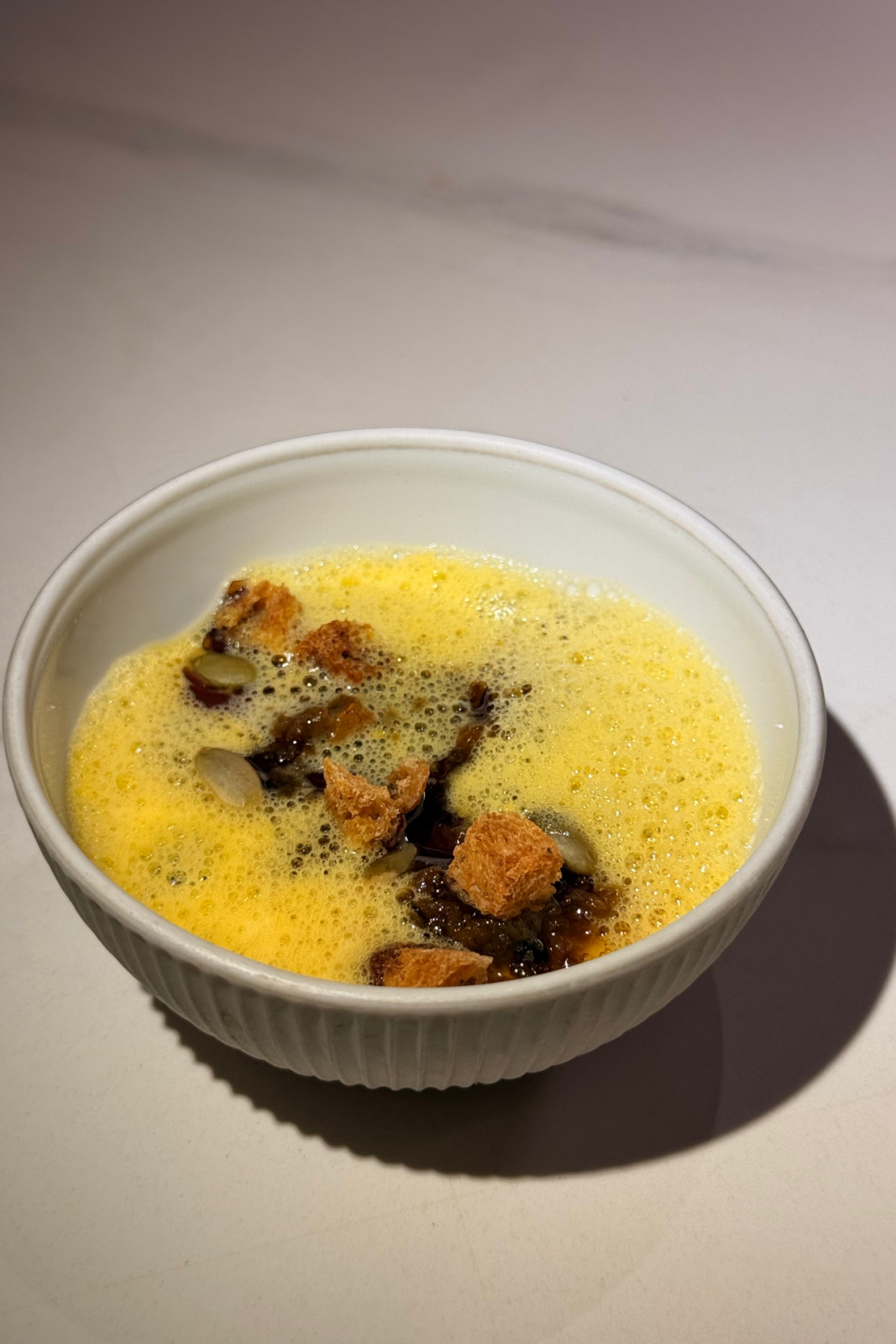 The pumpkin course from Helm by Josh Boutwood's Single Ingredient menu: Pumpkin custard, diced pumpkin, pumpkin XO sauce, pumpkin seed oil, lacto-fermented pumpkin syrup, pumpkin purée foam, roasted breadcrumbs, pumpkin seeds.