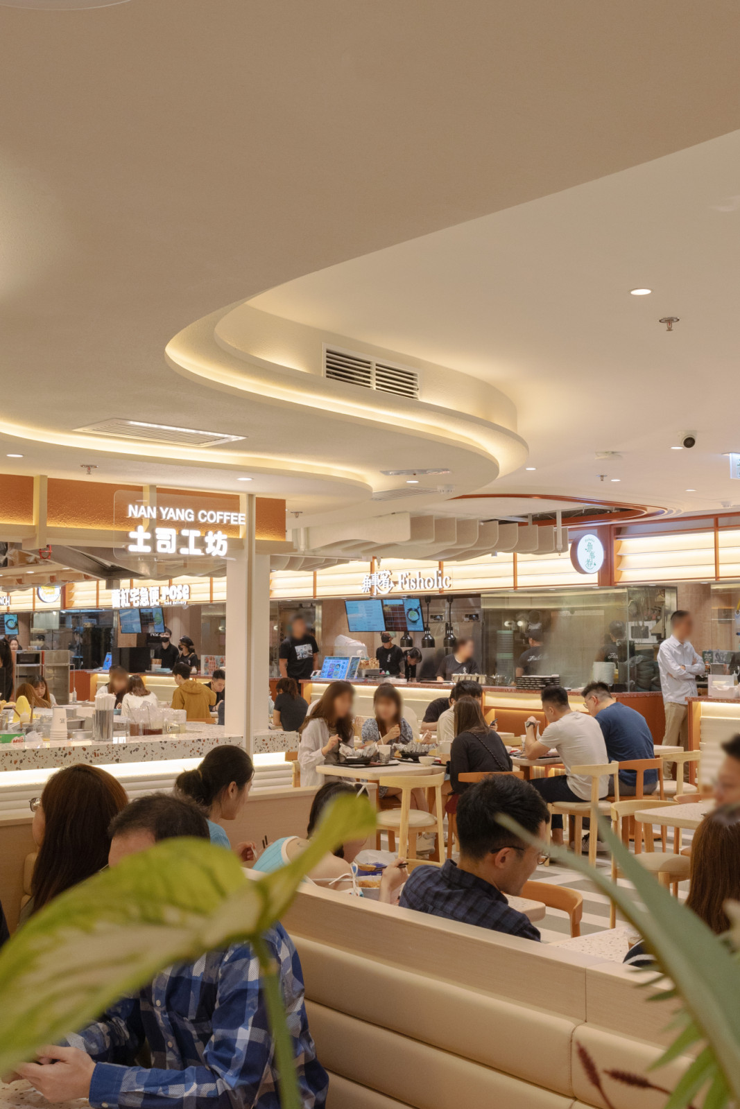 A modern food hall buzzes with diners, featuring outlets like NAN YANG COFFEE (土司工房) and Fisholic (鱼事者).