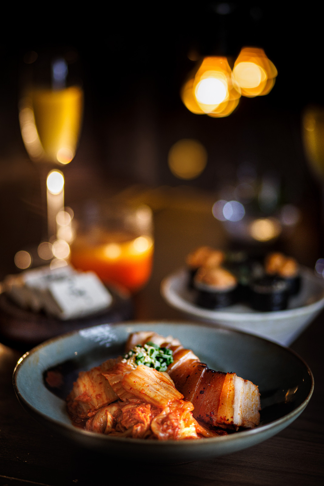Grilled pork belly is served with fresh kimchi, highlighting new interpretations of classic Korean dishes.