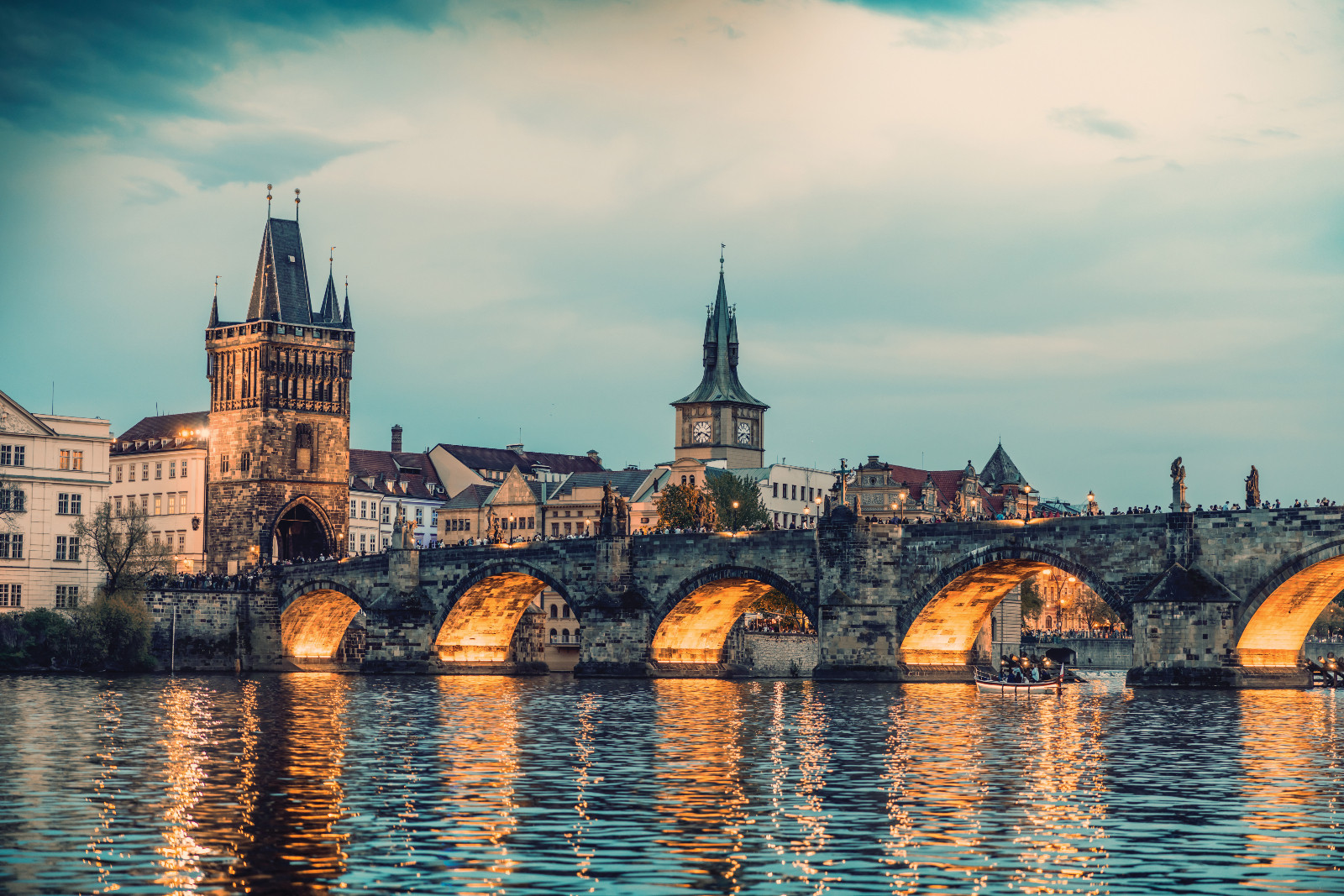 Prague's historic Charles Bridge glows at twilight, reflecting in the Vltava River. (Photo from Getty Images)