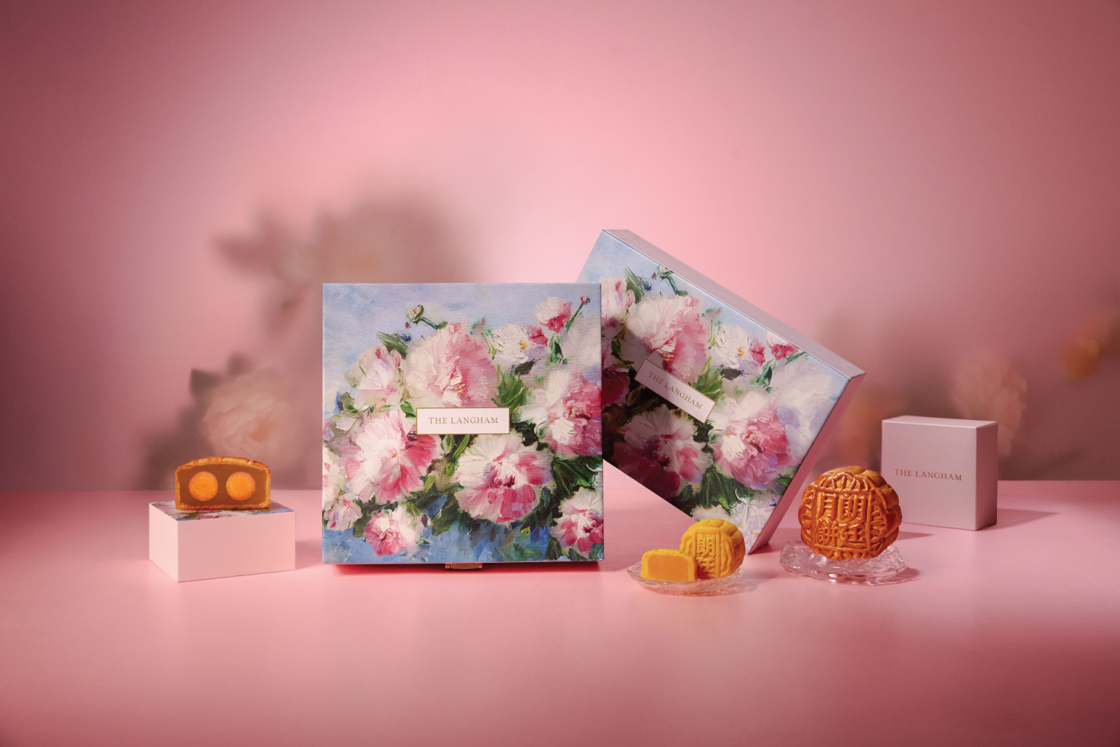 The Langham mooncakes, featuring traditional designs and rich fillings with salted egg yolks, are presented in luxurious floral packaging.