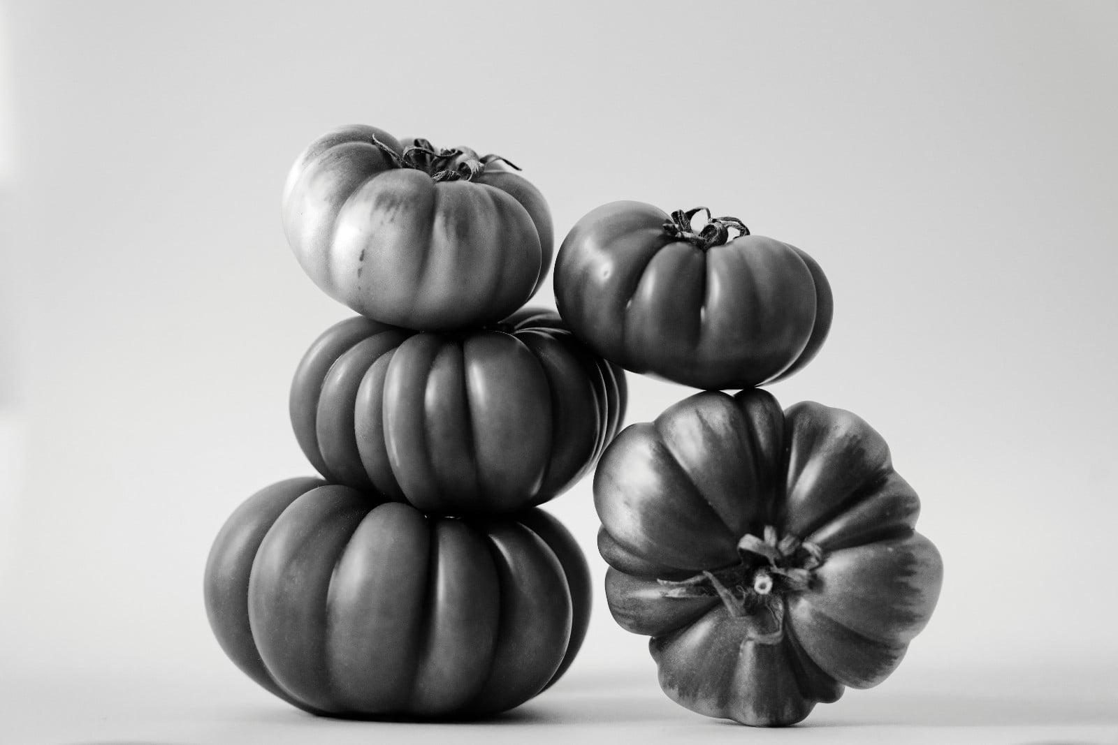 Ribbed heirloom tomatoes, artfully composed in a striking monochrome still life. (Photo by Sonny Thakur)