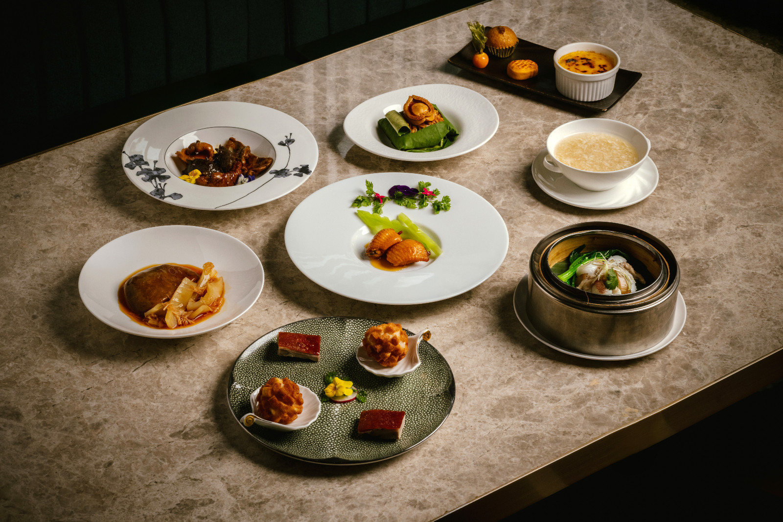 Meticulously presented Chinese fine dining dishes, including roasted meats, dim sum, and abalone.